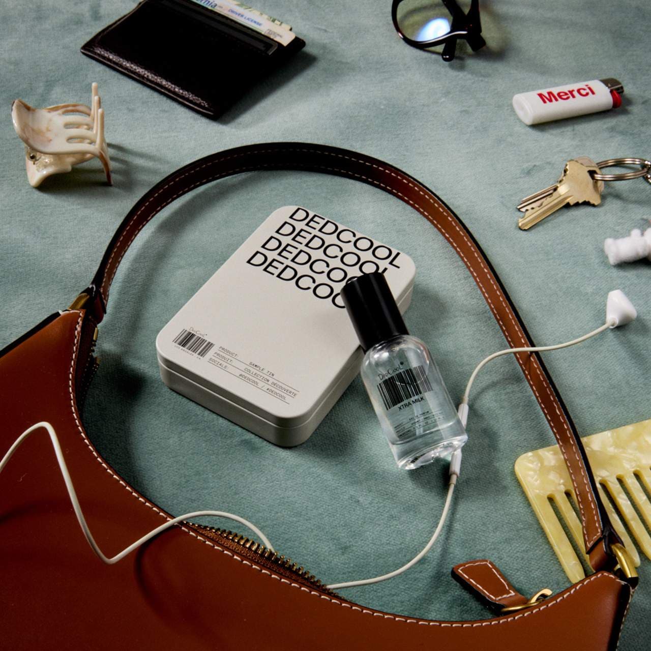 Set of Dedcool perfume samples with a branded case in the background