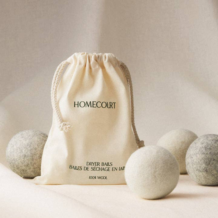 Homecourt dryer balls in a drawstring bag on a neutral background