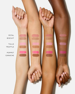 Four arms with makeup swatches on a white background