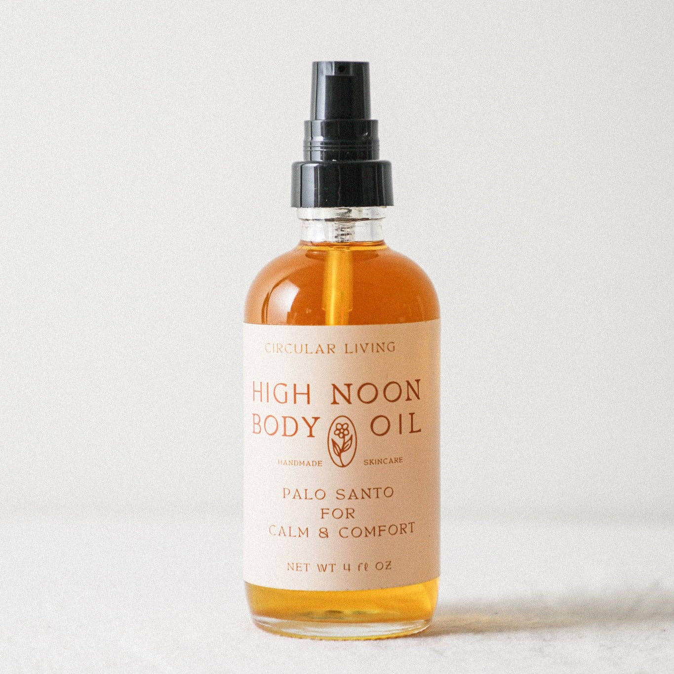 Bottle of High Noon Body Oil on a light background