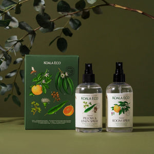 Two KOALA ECO spray bottles and a box on a green background with eucalyptus leaves.