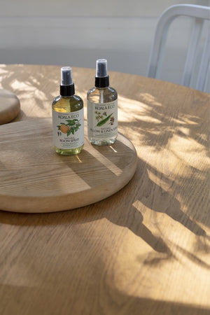 A bottle of Koala Eco room spray and a bottle of koala eco linen spray, on a wood table top
