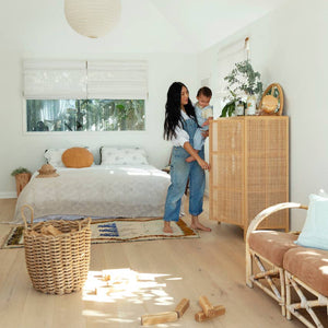 A woman and a child in a sunny bedroom with koala eco cleaning products. 
