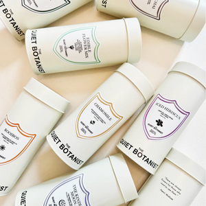 Collection of 'Quiet Botanist' skincare products on a light background