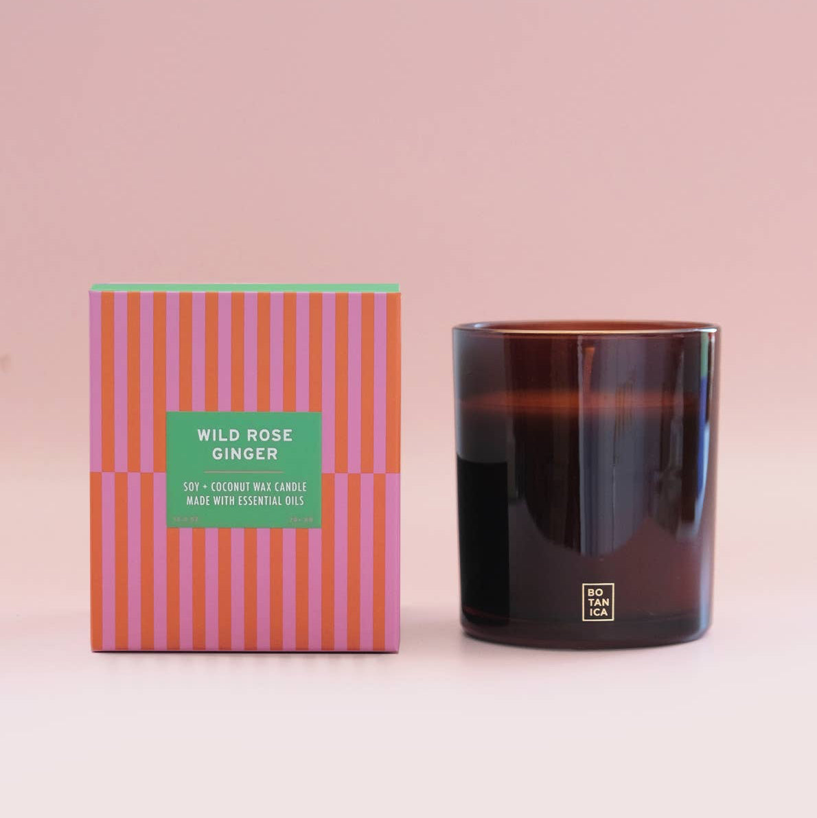 Candle and its packaging with a pink background