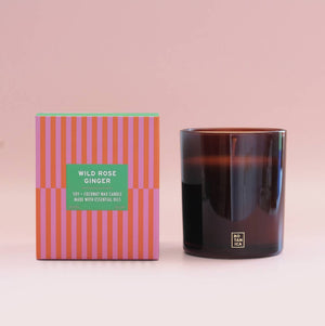 Candle and its packaging with a pink background