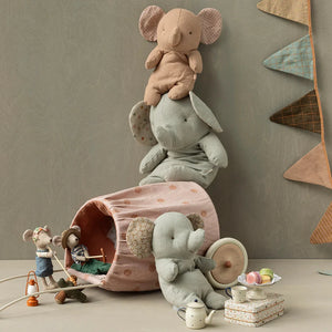Set of plush toys including elephants and a rabbit in a playful arrangement on a neutral background.