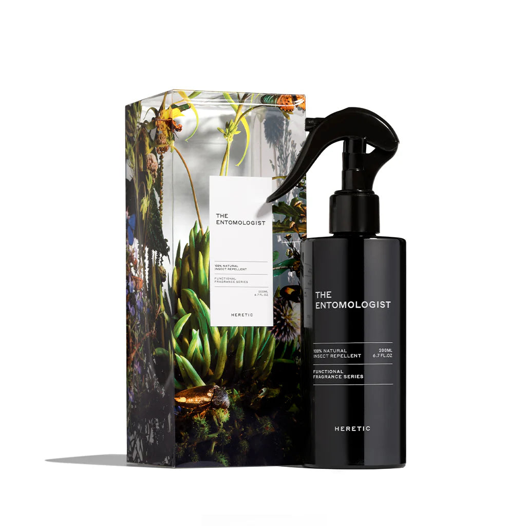 A product image featuring a black spray bottle labeled 'The Entomologist' next to its packaging box, which has a vibrant design with greenery and floral elements.
