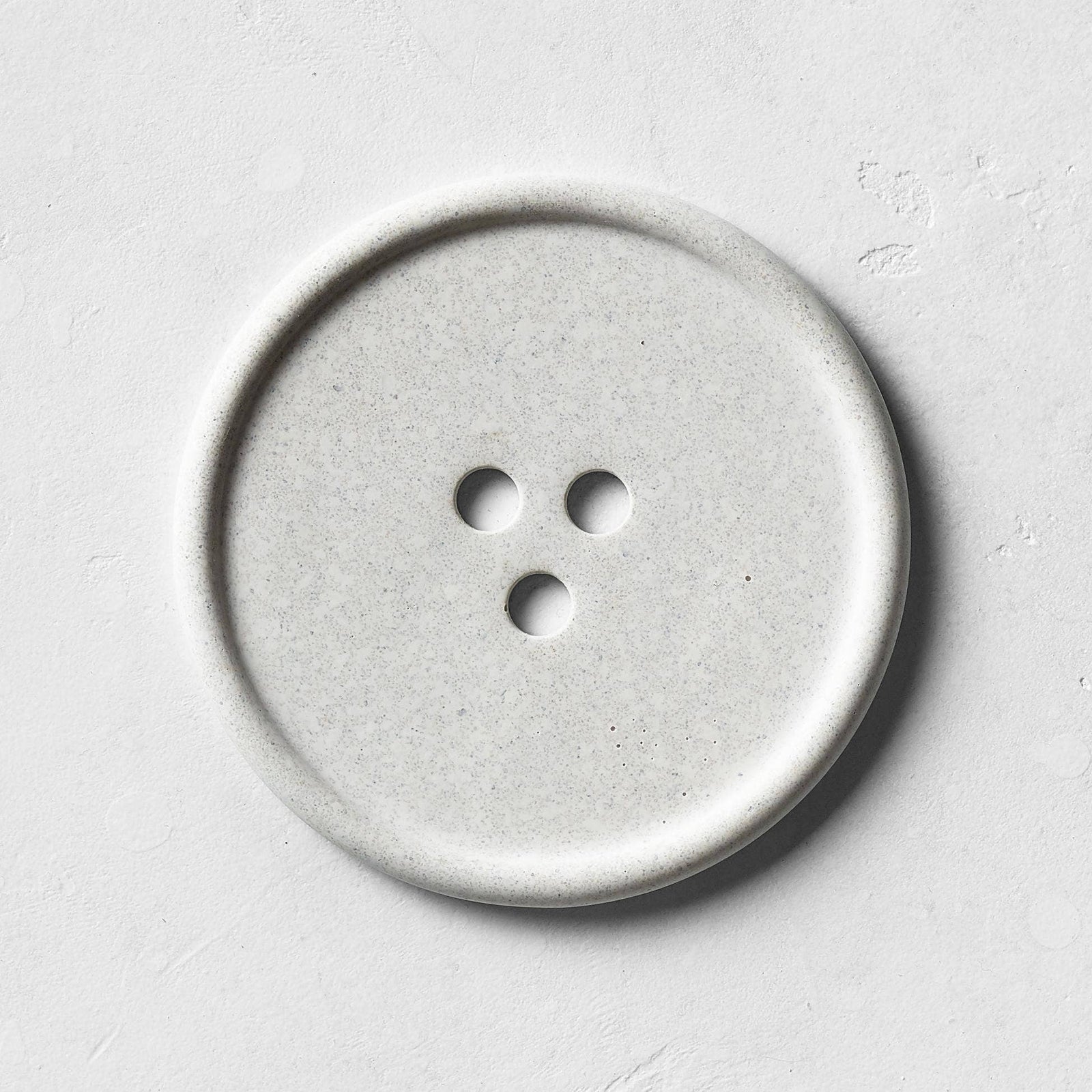 A gray bouton on a white surface. 