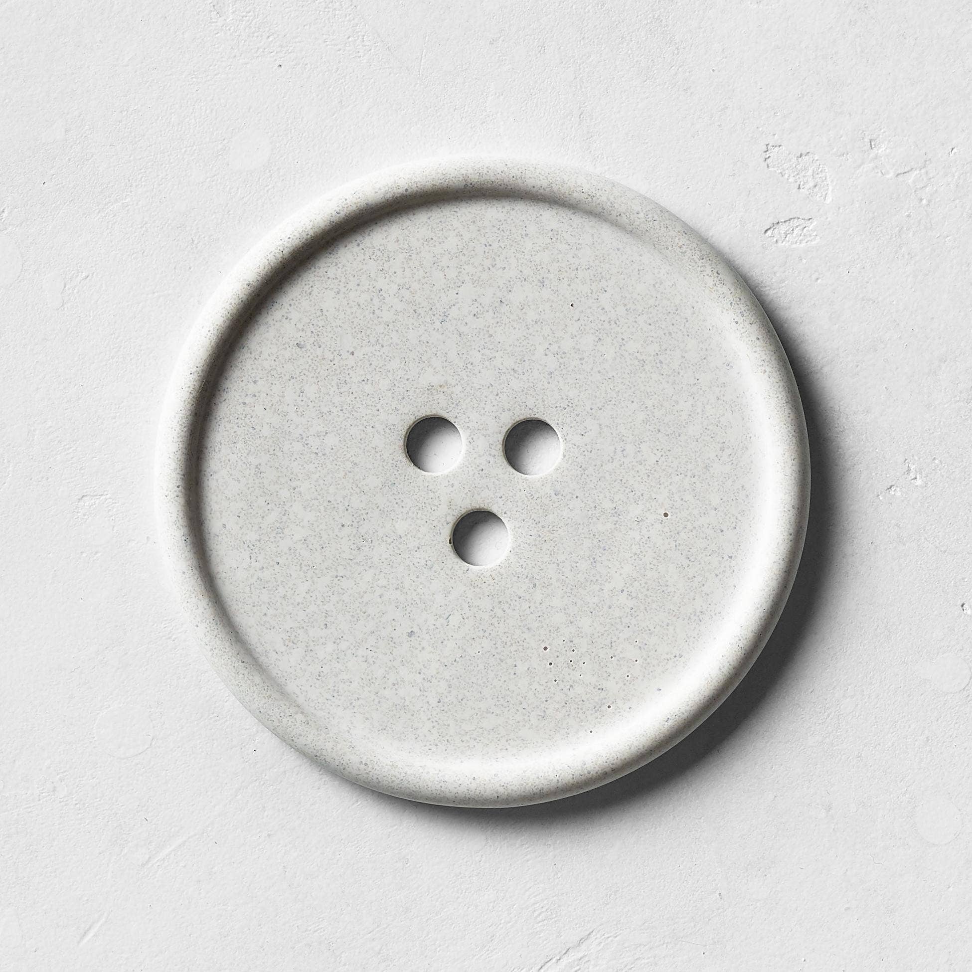 A gray bouton on a white surface. 