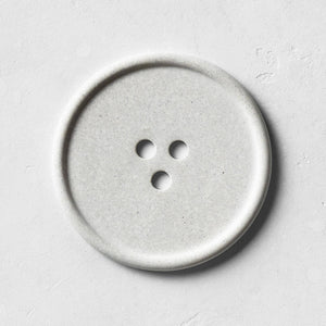 A gray bouton on a white surface. 