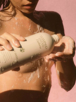 A woman pouring Flamingo Estate's Euphoria body wash into her hand