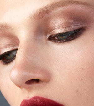 Close-up of a person's eye with smoky eyeshadow and red lipstick.