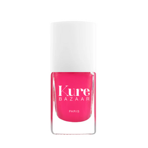 Pink nail polish bottle with white cap on a white background