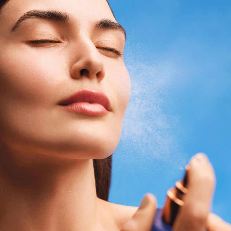 A bottle of Augustinus Bader The Face Mist, a blue bottle with a gold top