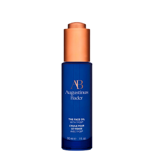 A blue bottle of The Face Oil with a copper cap