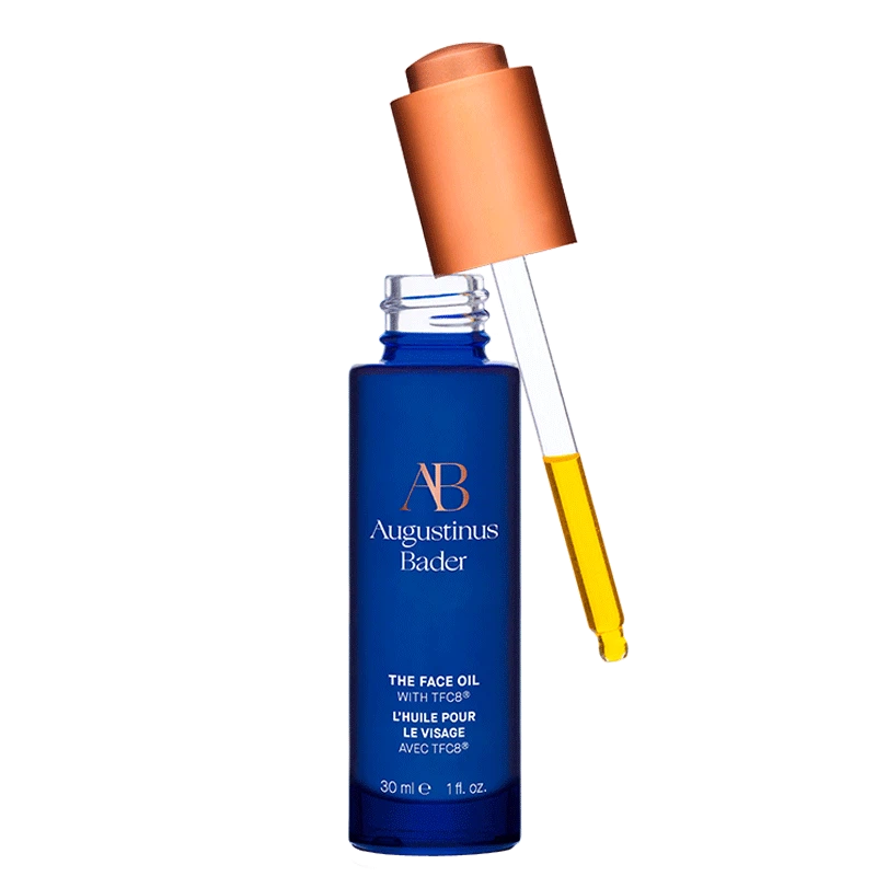 A blue bottle of The Face Oil with a copper cap