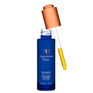 Blue skincare bottle with dropper labeled 'Augustinus Bader' on a white background