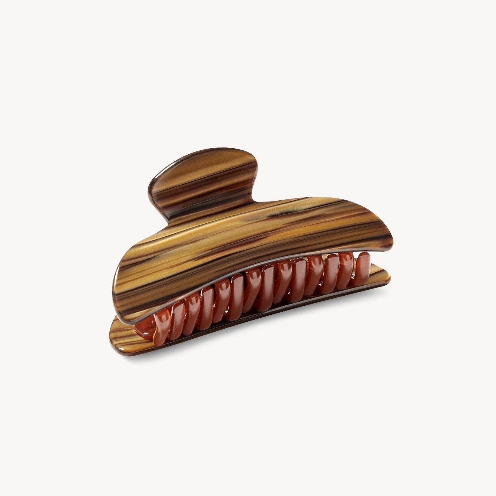 Wooden hair clip with a striped pattern on a white background