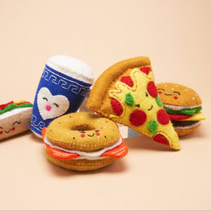 A group of felt dog toys, shaped like a bagel, a cup of coffee, a pizza slice, and a hamburger