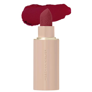 Lipstick with a beige casing and red lipstick on a white background, featuring the brand 'Westman Atelier'.