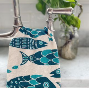 The Noon Designs fish tea towel is white with blue fish printed on it. 