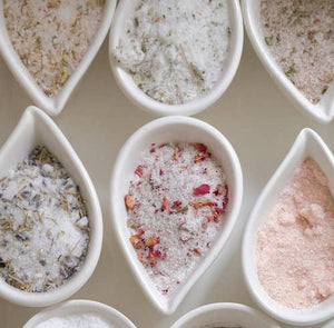 White dishes displaying different types of flavored salts