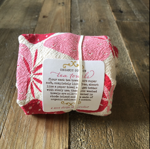 A flower sack tea towel on a wood surface. 