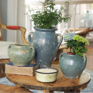 A room with a chair and wooden tables, with blue confit pots in the foreground. 