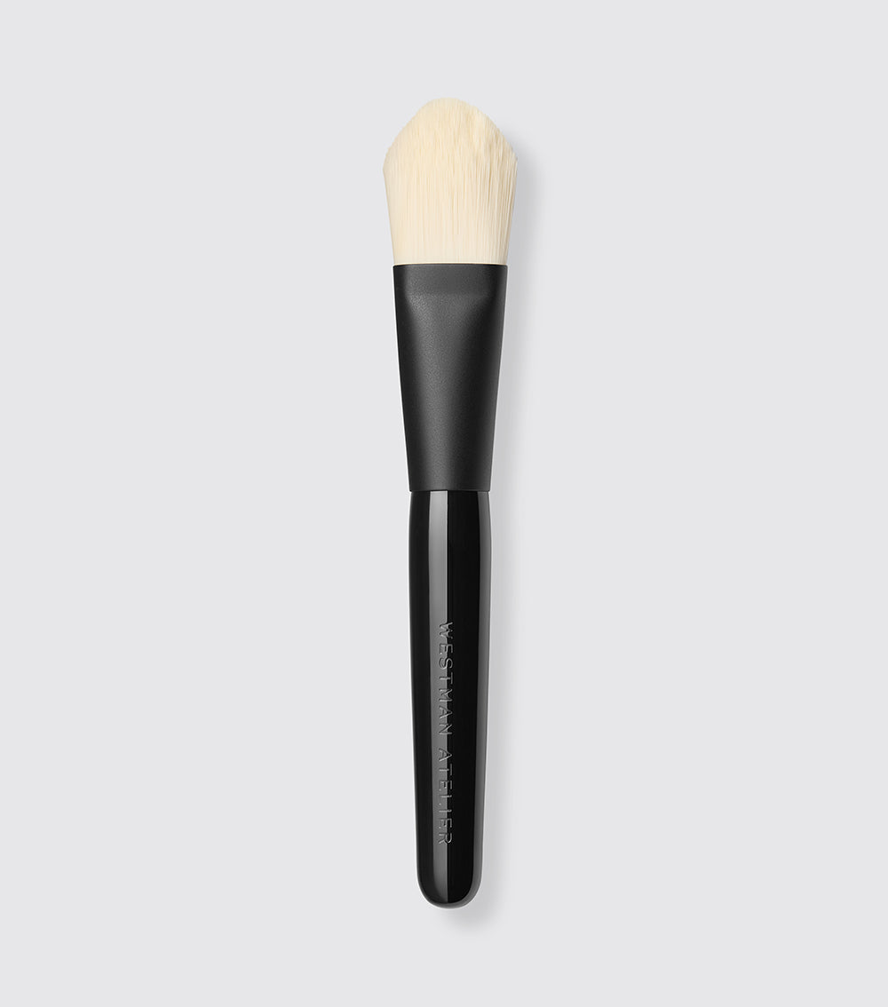 A paddle foundation brush with tapered, flat bristles and a black handle.