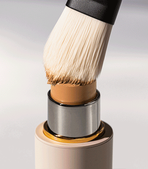 A brush applying a foundation stick