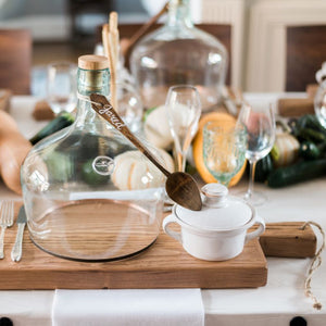 A table top with cutting boards, cloches, and wooden spoons. 