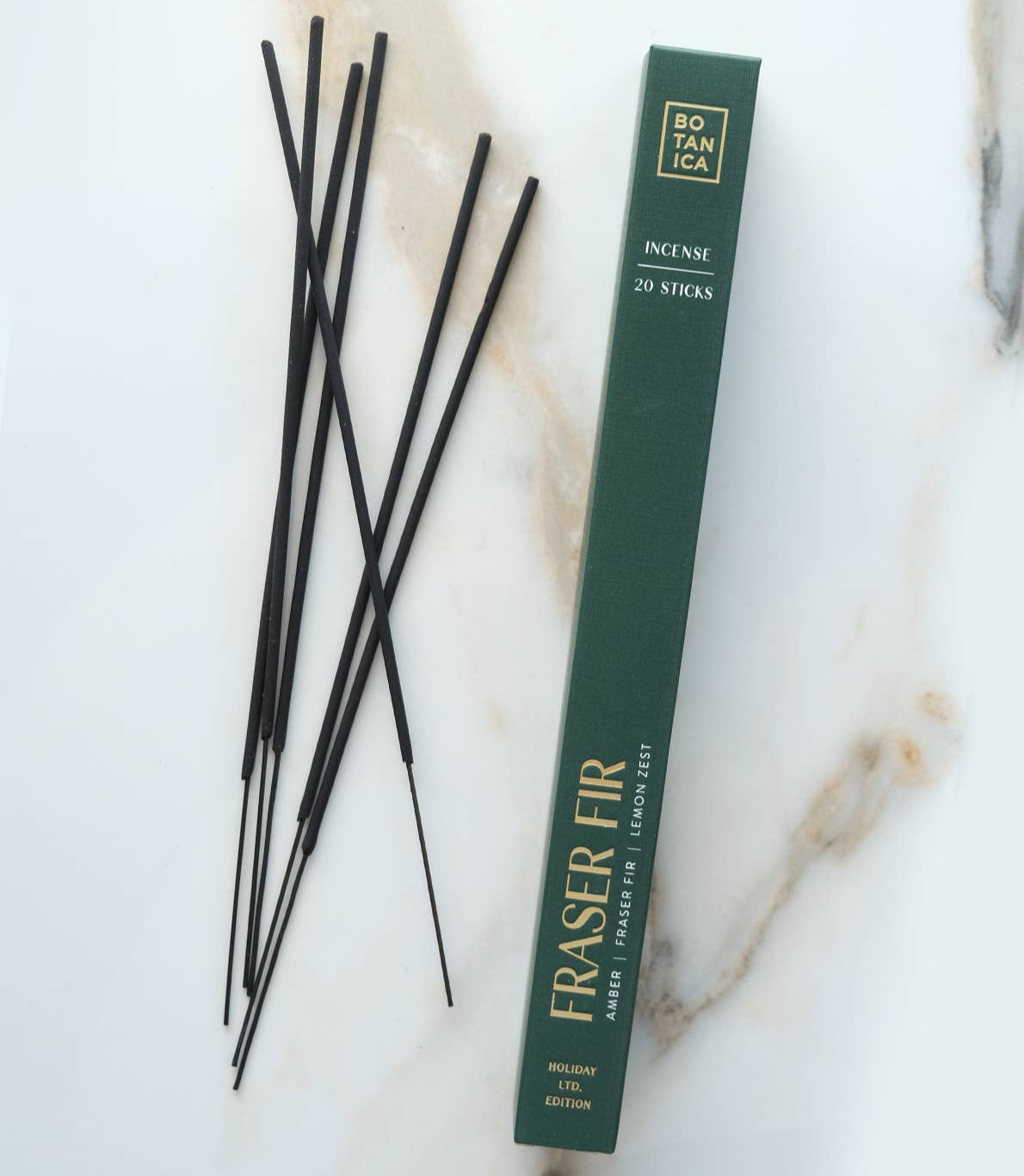 Incense sticks with a green box on a marble surface