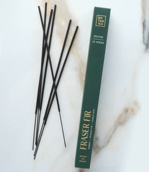 Incense sticks with a green box on a marble surface