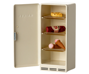 Beige refrigerator with ice cream cones and a cake on a white background