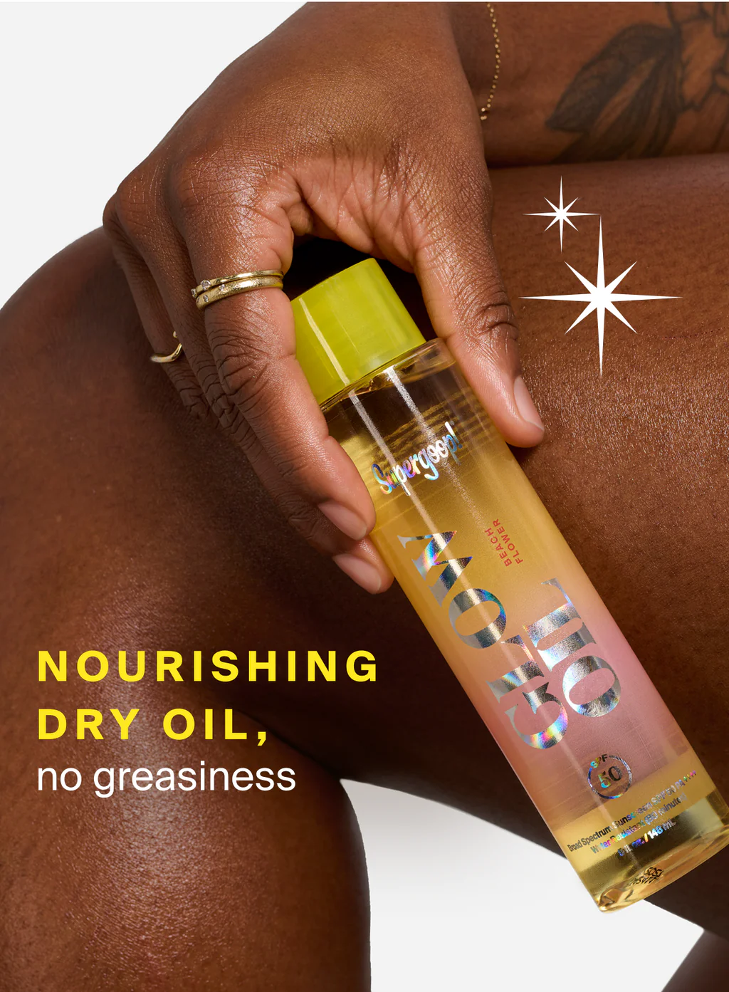 Hand holding a bottle of dry oil with text 'Nourishing Dry Oil, no greasiness' on a white background.