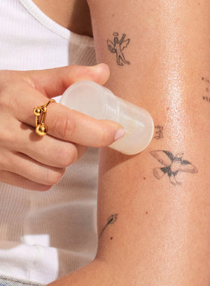 Person applying the Glowstick to their arm with visible tattoos.