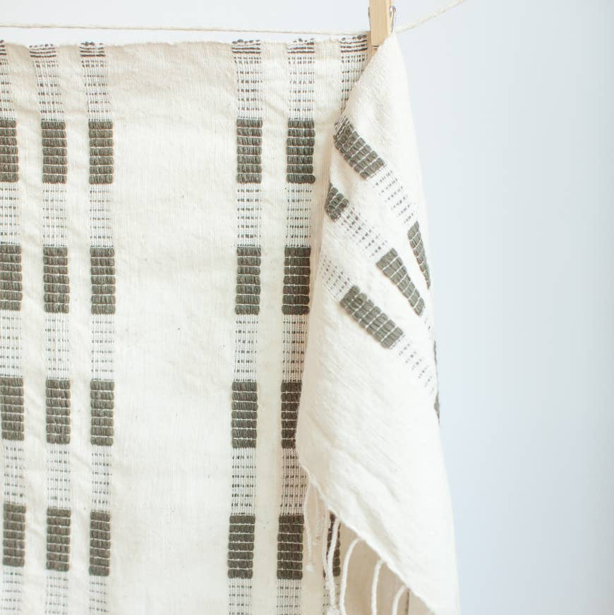 A green and white tea towel with a clothespin.