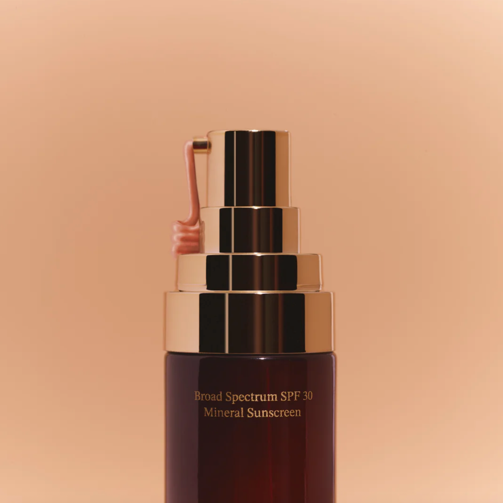 Mineral sunscreen bottle with gold cap on a beige background