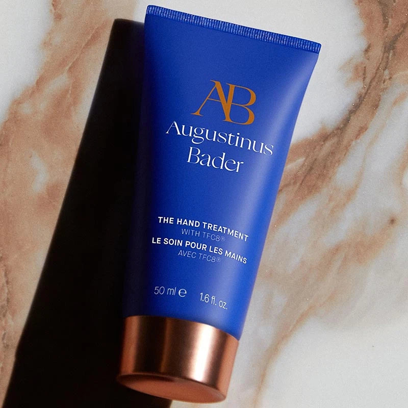 Blue tube of Augustinus Bader hand treatment on a marble surface