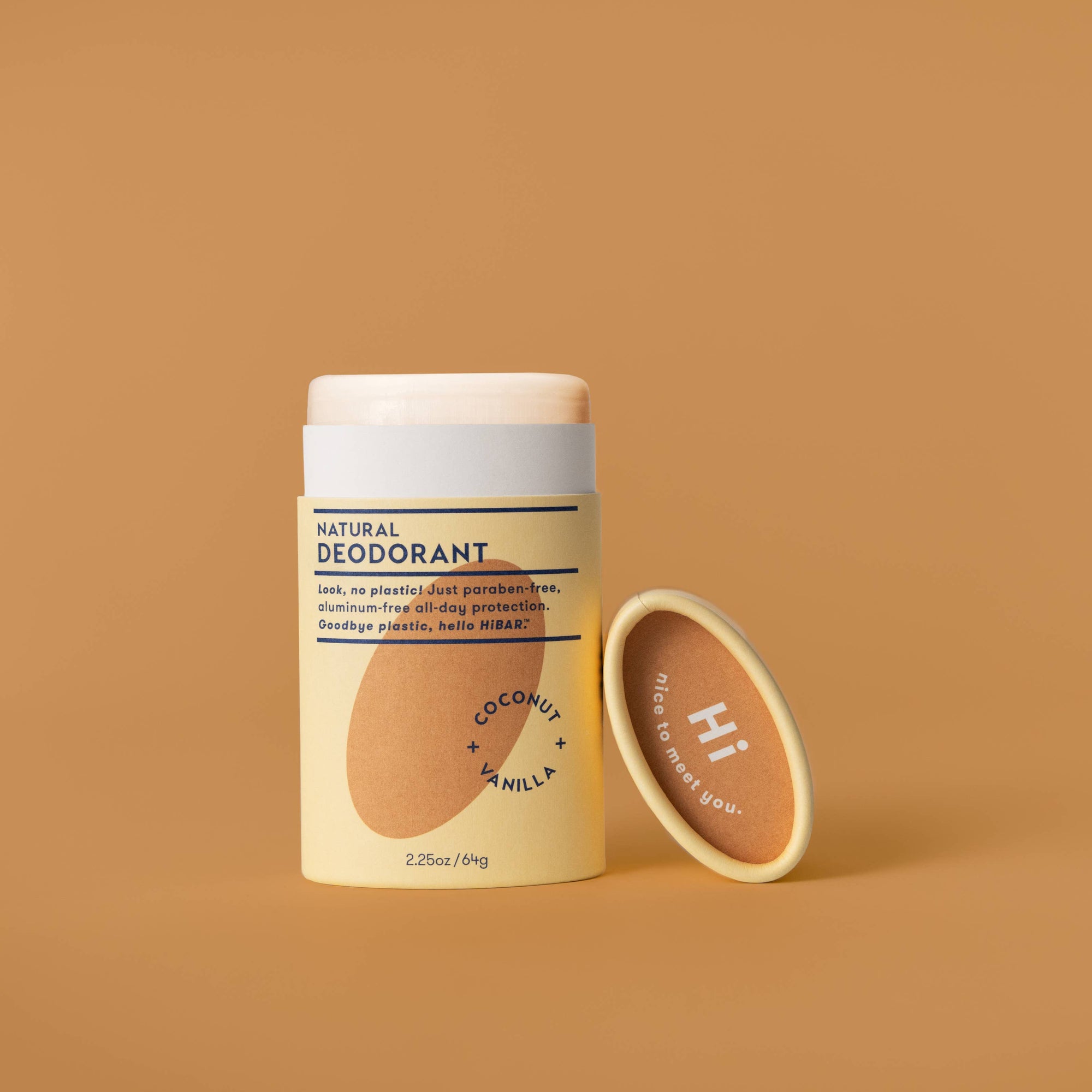 A stick of HiBAR deodorant with a coconut and vanilla scent, presented in a beige and yellow packaging, placed on a beige background.