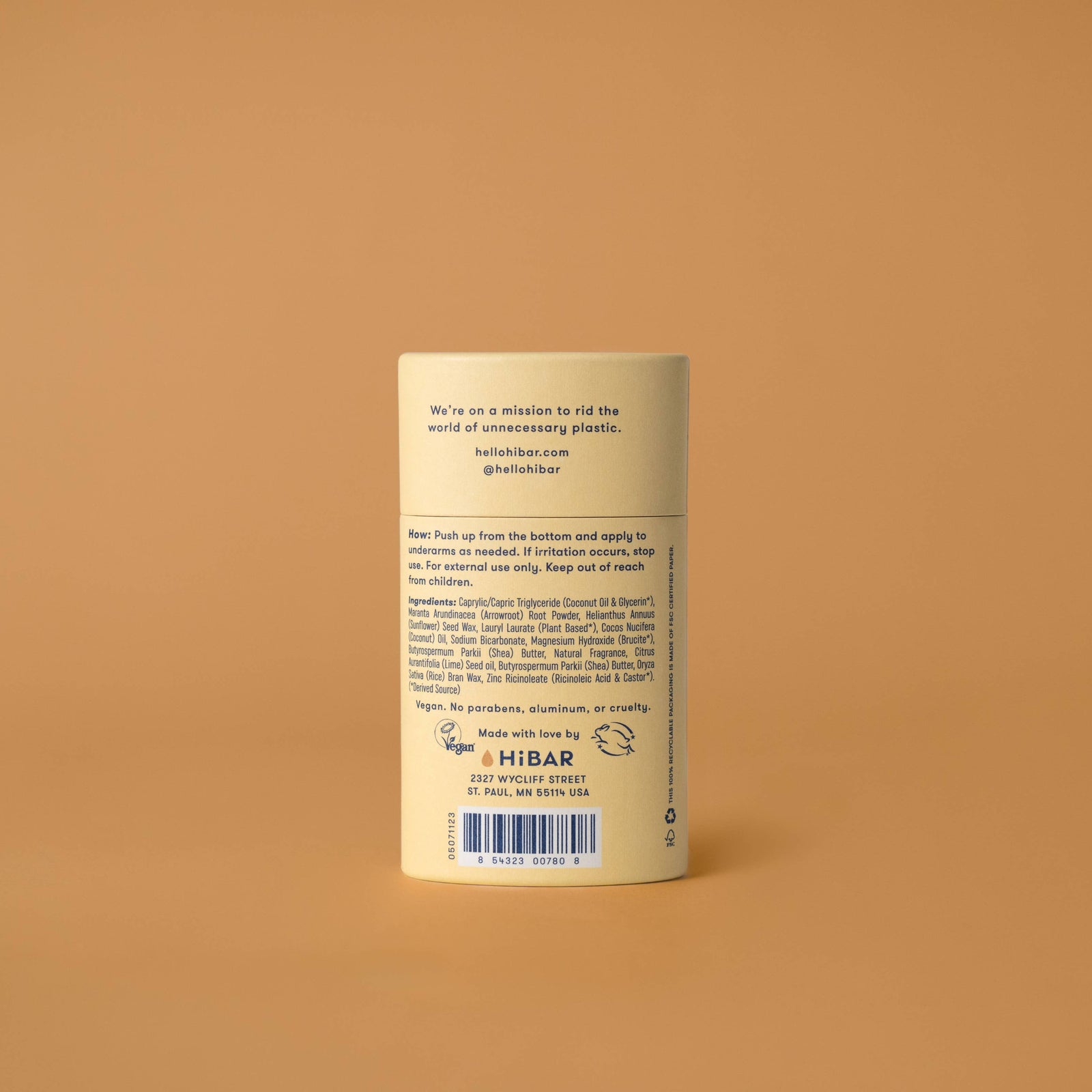 A stick of HiBAR deodorant with a coconut and vanilla scent, presented in a beige and yellow packaging, placed on a beige background.
