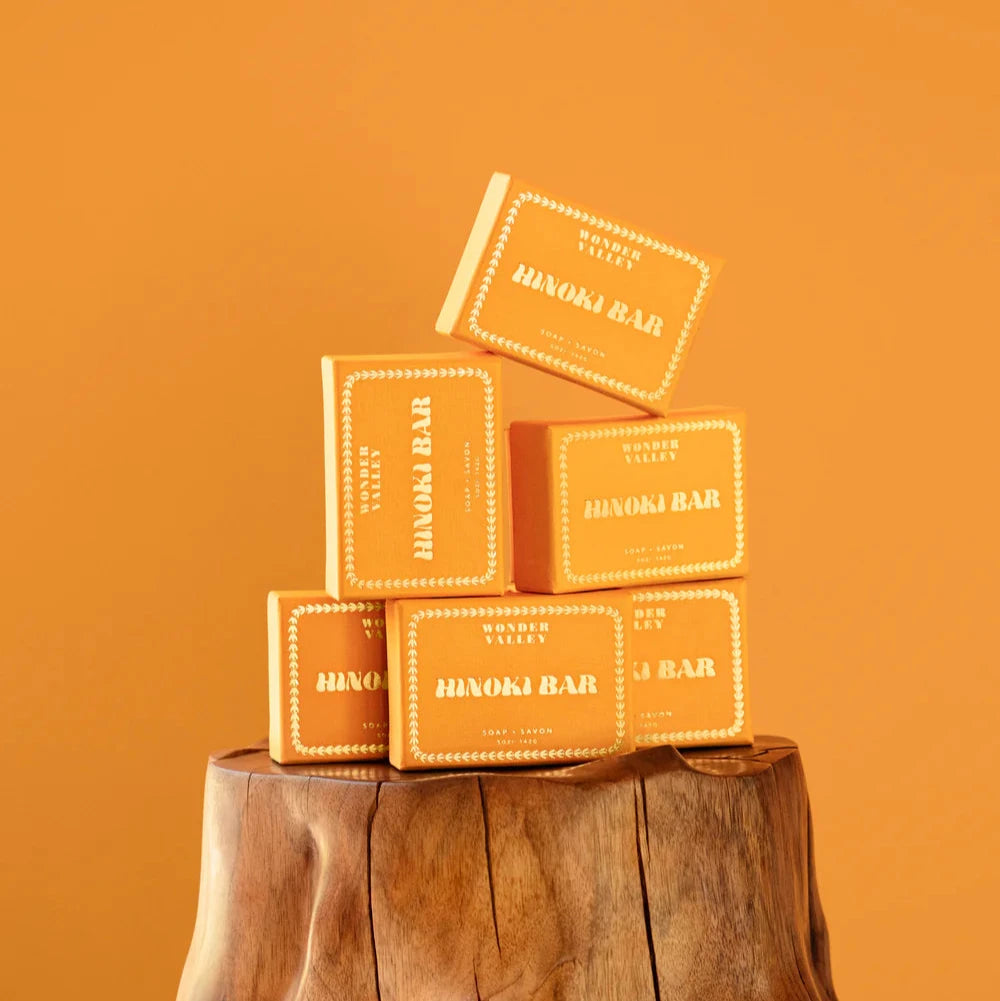A stack of hinoki bars, made in California by Wonder Valley, atop a stump