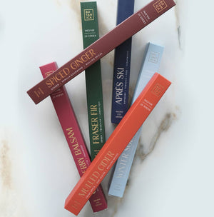 Collection of scented candles in various colors on a marble surface