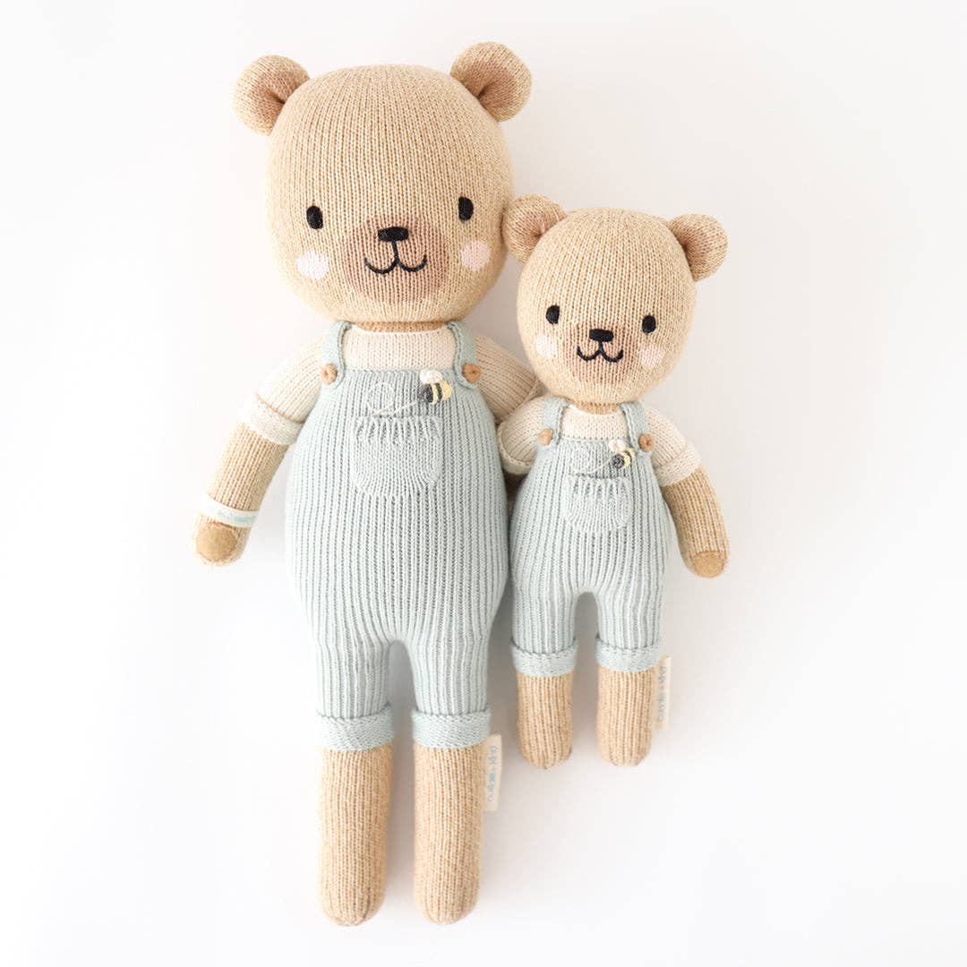 One large honey bear stuffed animal and one small one. Both are light brown with light blue overalls. 