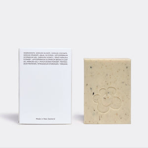 Bar of soap with a white card displaying text on a light gray background