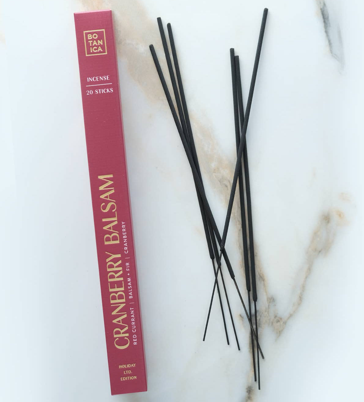 Cranberry Balsam incense sticks with packaging on a marble surface