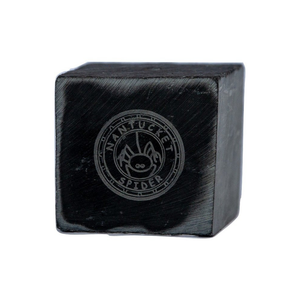 A solid black slate incense holder with the Nantucket Spider logo engraved on the top.