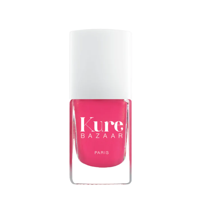 A bottle of Kure Bazaar nail polish in a pink shade with a glossy finish.