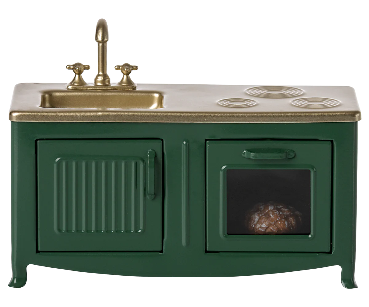 A dark green toy kitchen with a sink, oven, and cabinets, featuring a gold-colored faucet and black accents.